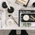 Luxury candle subscription flat lay on marble surface with black matte candle, matchsticks, and gold accents